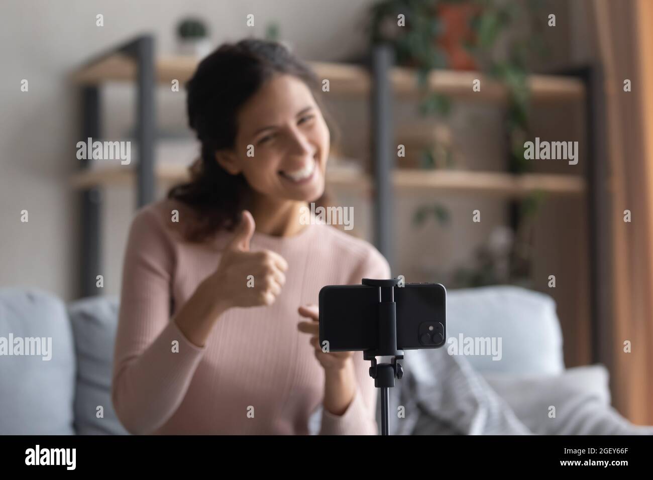 Frau zeigt Daumen nach oben aufnehmen kommerziellen Video vlog auf Handy Stockfoto