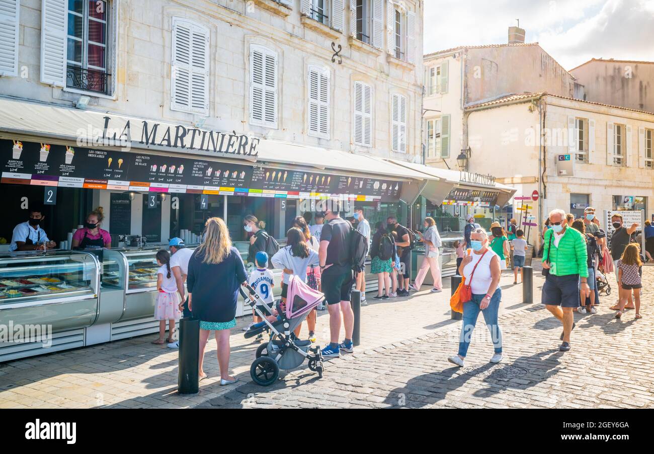 30 July 2021 , Saint-Martin-de-Ré Frankreich : Touristen, die in der Eisdiele La Martinière im alten Hafen von Saint-Martin-de-Ré anstehen, eine berühmte lokale Kunst Stockfoto