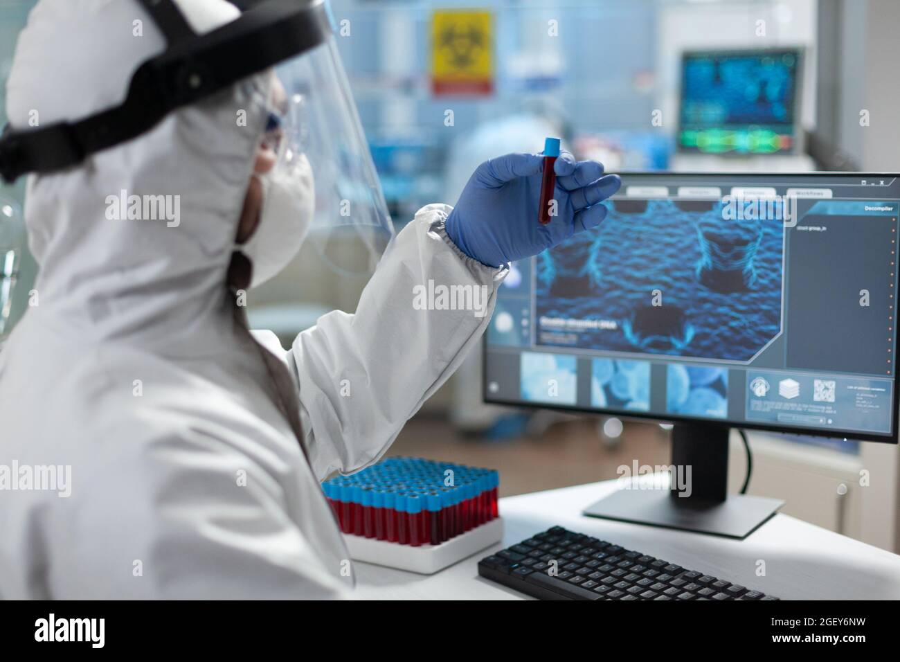 Chemiker Forscher hält medizinische Reagenzglas mit genetischer Blut in den Händen Analyse klinischer Expertise während der Biochemie Experiment. Wissenschaftler mit PSA-Schutzausrüstung im wissenschaftlichen Labor Stockfoto