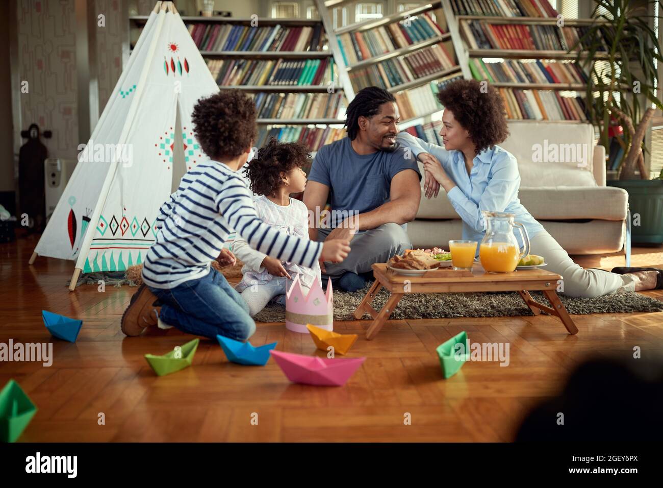 Eine junge Familie genießt Essen und spielt in entspannter Atmosphäre zu Hause zusammen. Familie, Zuhause, zusammen, Spielzeit Stockfoto