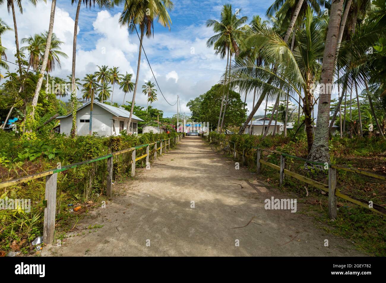 Raja Ampat, West Papua, Indonesien, ist eine der Straßen in der kleinen Stadt Friwin, umgeben von bescheidenen kleinen Häusern und tropischen grünen Pflanzen Stockfoto