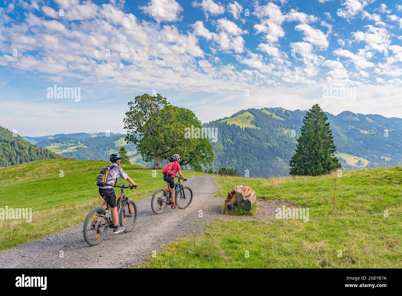 Nette und verbliebene junge Großmutter und ihr Enkel auf ihren Elektro-Mountainbikes in den Allgäuer Alpen bei Oberstaufen in Bayern, Deutschland Stockfoto