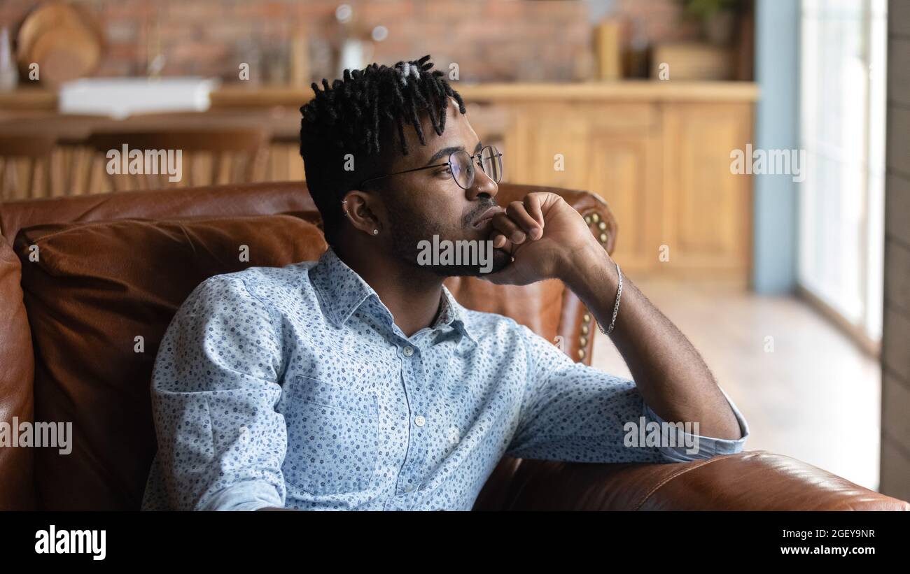 Nachdenklich gelangweilt Millennial Black gemischt Rennen Kerl in Gedanken verloren Stockfoto