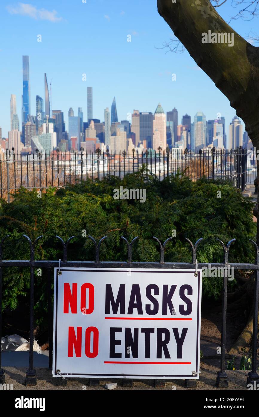 WEEHAWKEN, NJ – 14. MÄRZ 2021 – Blick auf ein Schild mit der Aufschrift Keine Maske kein Zutritt mit der Skyline von Manhattan, New York im Hintergrund. Stockfoto