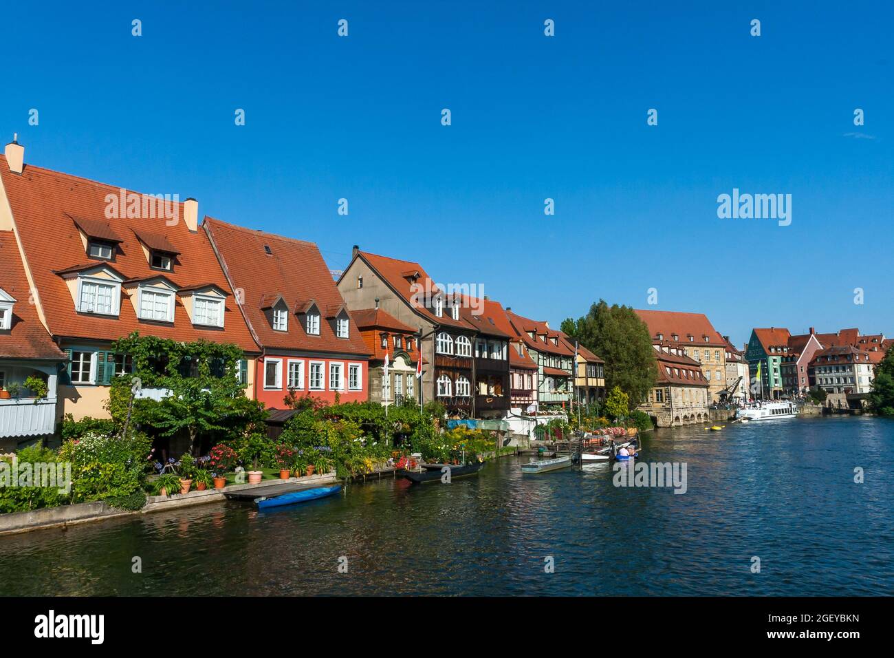 Malerischer Blick auf die mittelalterlichen Gebäude entlang der Regnitz mit alten Lastkahn, festfahrenden Booten und am Ufer, Bamberg Deutschland Stockfoto