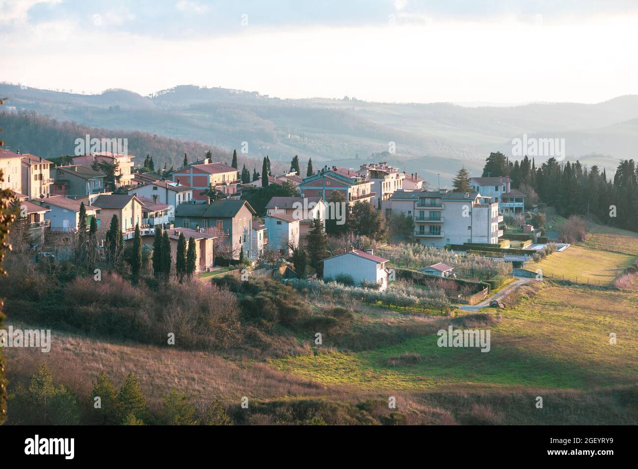 Luftaufnahme eines kleinen italienischen Dorfes in der Toskana. Hügel und grüner Rasen, typisch italienische ländliche Landschaft. Wohnungen bei Sonnenuntergang. San Cascia Stockfoto