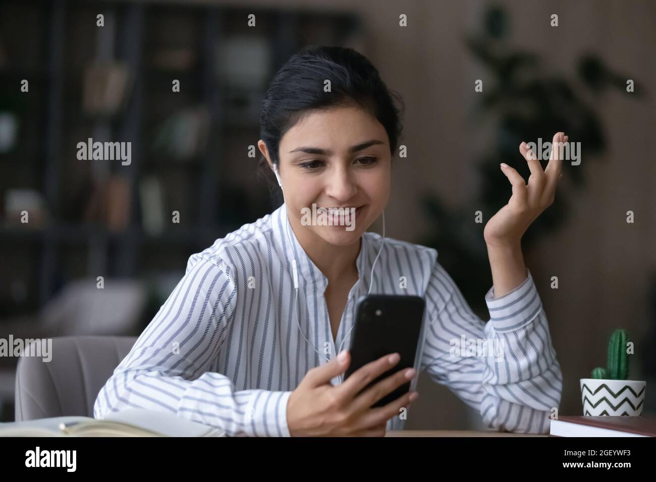 Lächelnde Inderin hat Webcam-Anruf auf Handy Stockfoto