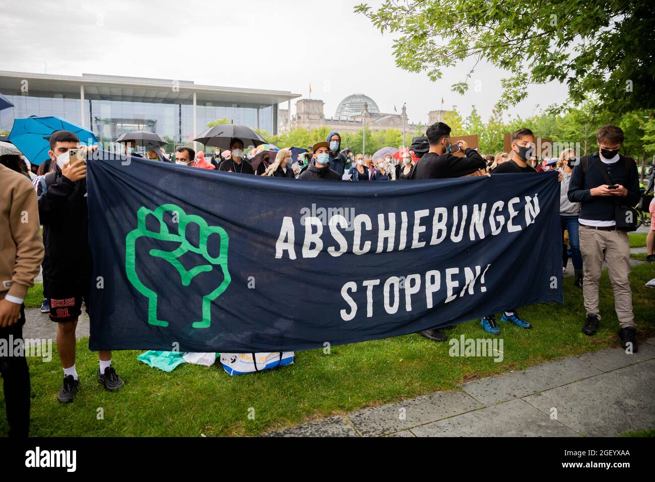 Berlin, Deutschland. August 2021. Teilnehmer einer Demonstration einer breiten Allianz für die Aufnahme von Menschen aus Afghanistan halten ein Transparent mit der Aufschrift „Stoppt die Abschiebungen!“ Vor dem Bundeskanzleramt, rechts im Hintergrund das Reichstagsgebäude. Quelle: Christoph Soeder/dpa/Alamy Live News Stockfoto