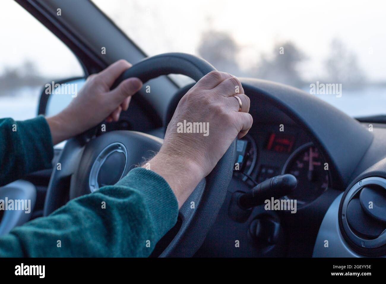 Reifer Mann fährt ein Auto auf einer Winterstraße, Innenansicht Stockfoto