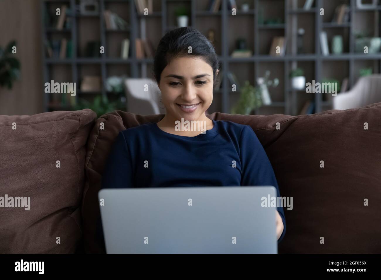Lächelnde indische Frau verwenden Laptop online arbeiten Stockfoto