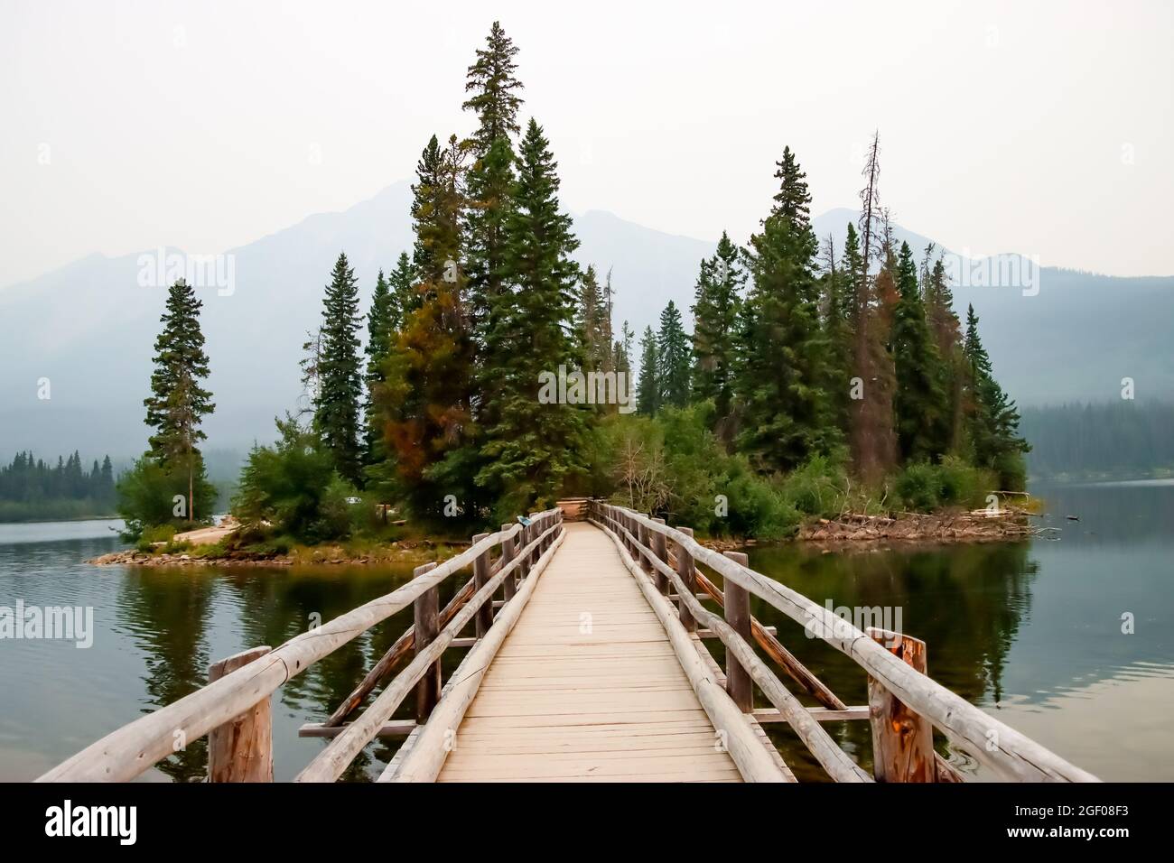 Nahaufnahme einer Fußgängerbrücke aus Holz, die zu einer kleinen Insel am Pyramid Lake in Jasper, Alberta, führt Stockfoto