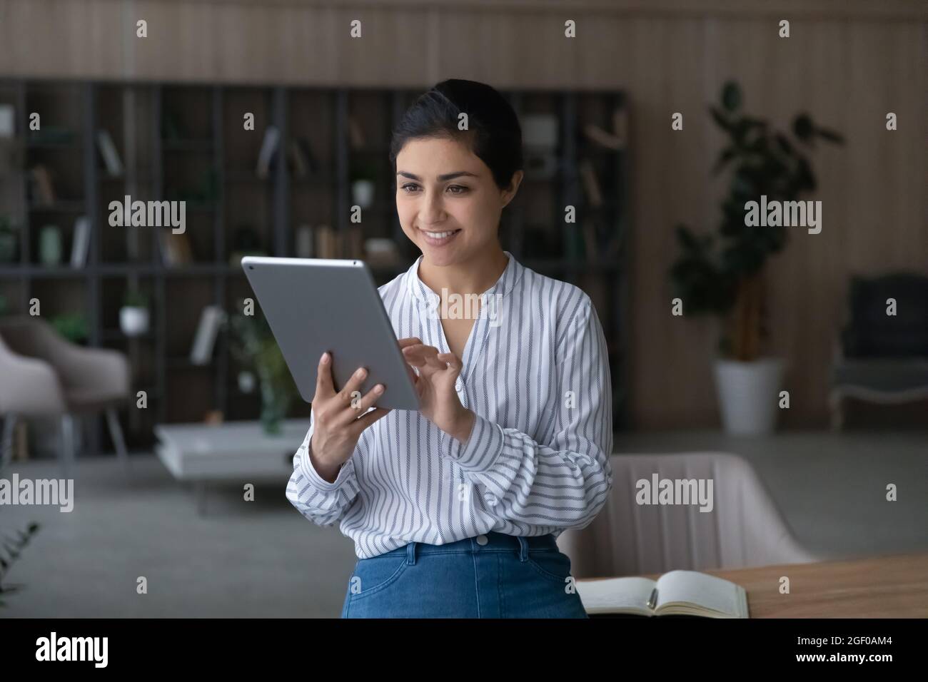 Lächelnde indische Frau verwenden Tablet im Internet surfen Stockfoto