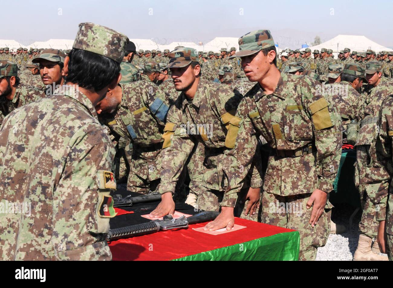 Rekruten der afghanischen Nationalarmee legen während der Eid-Zeremonie zur Grundausbildung von Kriegern im regionalen Militärausbildungszentrum am 13. Oktober 2011 in Kandahar, Afghanistan, ihre Hände auf den Heiligen Koran. Fast 1400 Rekruten versprachen ihre Treue zur Regierung und der Bevölkerung Afghanistans. (Luftwaffe Foto von MSgt Paul Hughes) Stockfoto