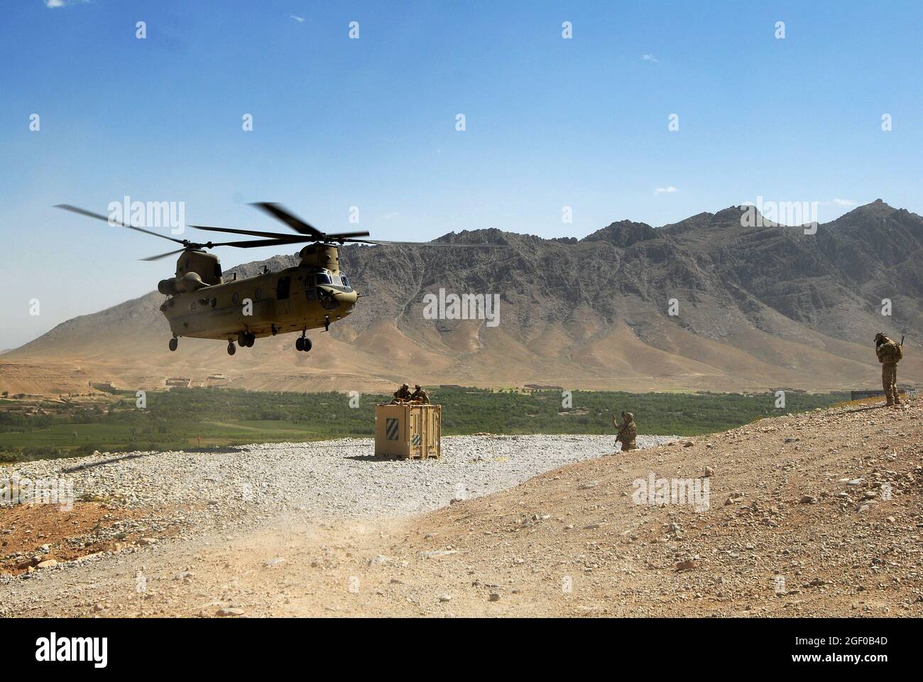 Ein CH-47 Chinook wird in Richtung eines Containers für Schlingentraglast in Chorah, Afghanistan, 12. Mai 2013 geführt. Die Chinooks, geflogen von Mitgliedern der Bravo Company, des 2. Bataillons, des 104. Luftfahrtregiments der Nationalgarde der Connecticut und Pennsylvania Army, haben seit ihrer Ankunft im Dezember 2012 durch Nachschub-, Rückschritt- und geplante Einsätze eine wichtige Rolle bei der Mission in Afghanistan gespielt. (USA Armeefoto von Sgt. Jessi Ann McCormick) Stockfoto