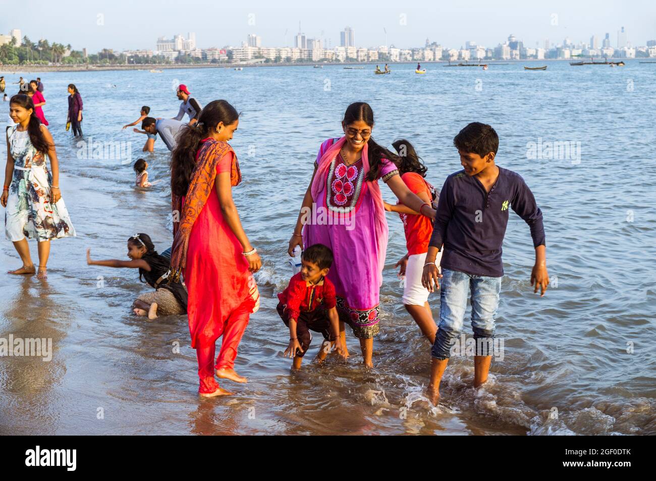 Mumbai, Maharashtra, Indien : die Menschen entspannen sich am Girgaon Chowpatty Strand. Schiffsfahrt und Nariman Point im Hintergrund. Stockfoto