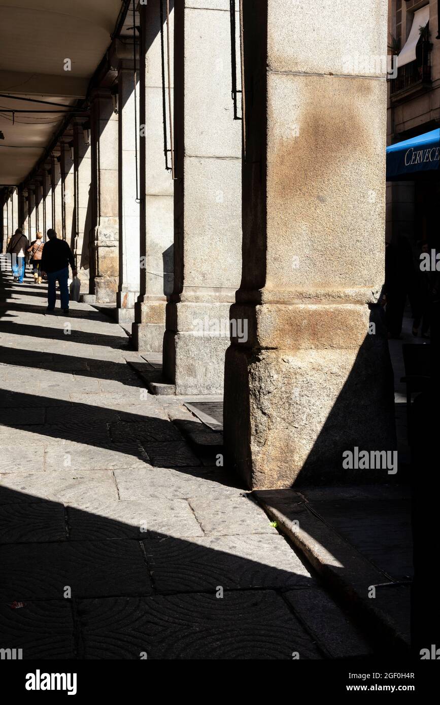 Spaziergang im Schatten des Arkadenwegs in der Calle de Toledo, im Zentrum von Madrid, Spanien Stockfoto