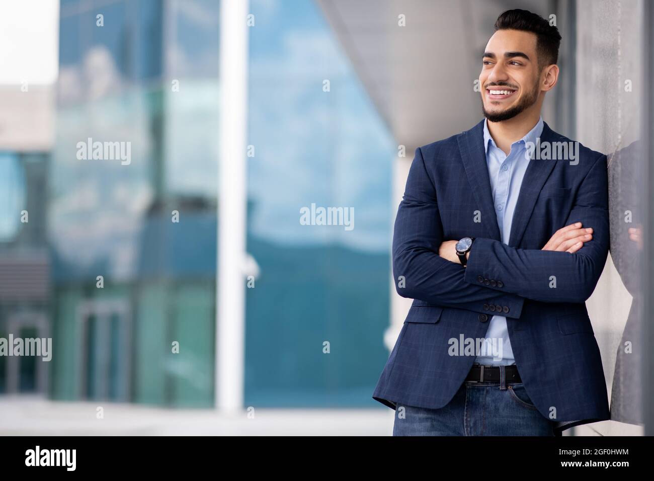 Glücklicher arabischer Mann wohlhabender Geschäftsmann, der neben dem Geschäftszentrum steht Stockfoto
