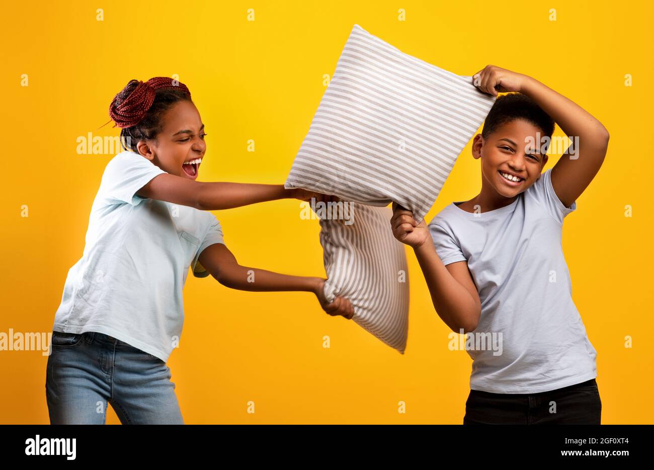 Verspielte afroamerikanische Schwester und Bruder mit Kissenschlacht Stockfoto