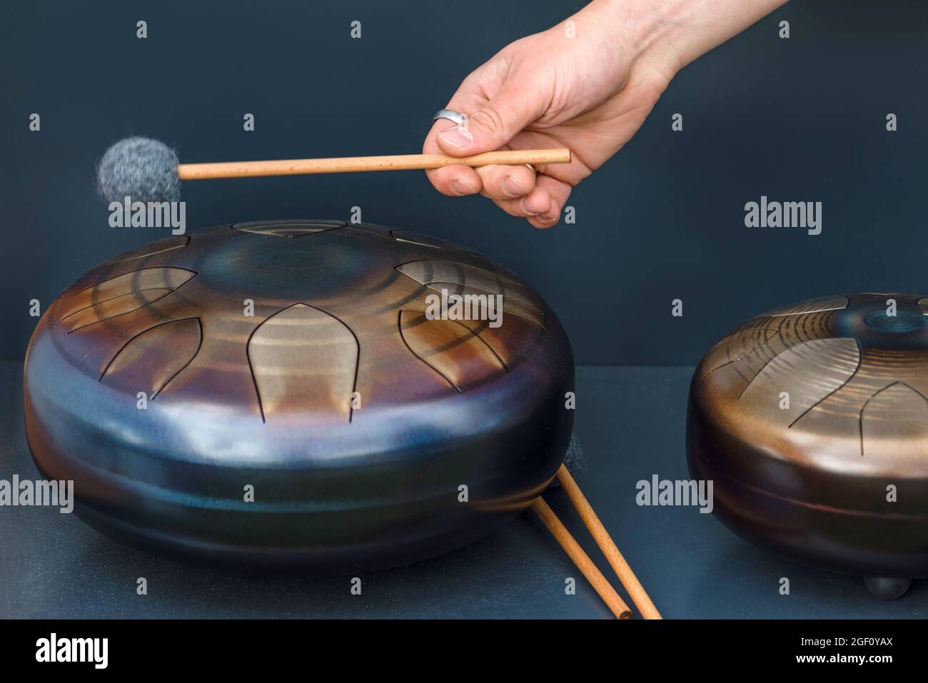 Stahlzunge, Trommel. Klangschale, Stahltrommel und Drumsticks. Instrument für Klangwellentherapie und Meditation, Heilung. Stockfoto