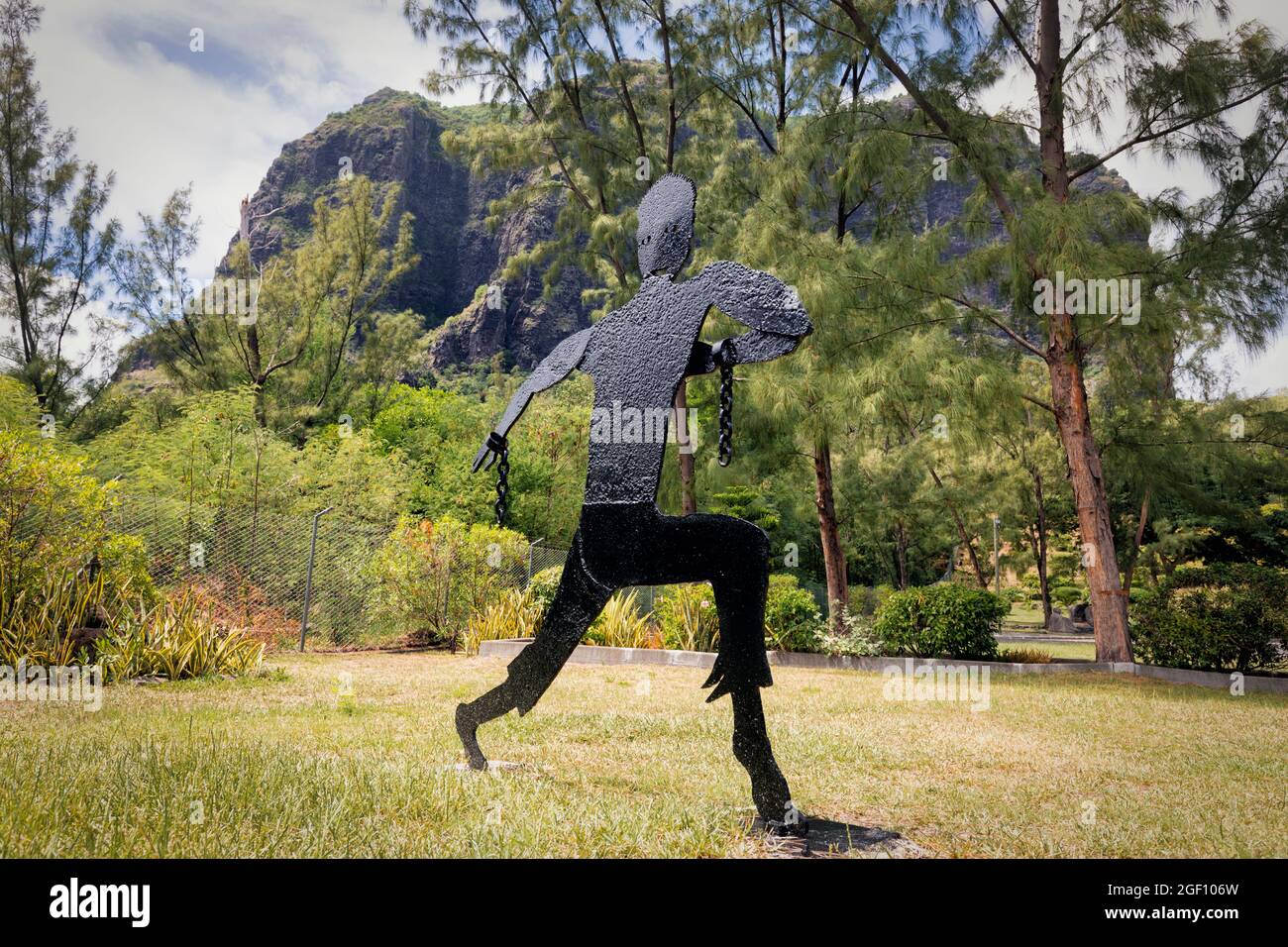 Mauritius, Mascarene-Inseln. Metallskulptur eines entweichenden Sklaven. Das Denkmal der Sklavenstraße am Fuße des Berges Le Morne Brabant. Der Berg wa Stockfoto
