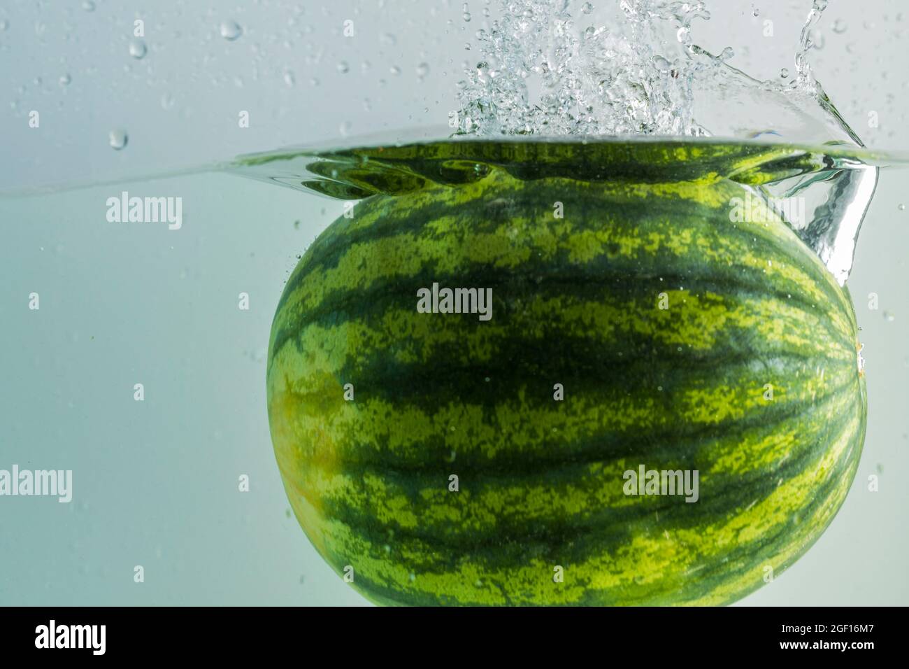 Nahaufnahme der Wassermelone, die auf türkisfarbenem Hintergrund ins Wasser  fällt. Wunderschöne Hintergründe Stockfotografie - Alamy
