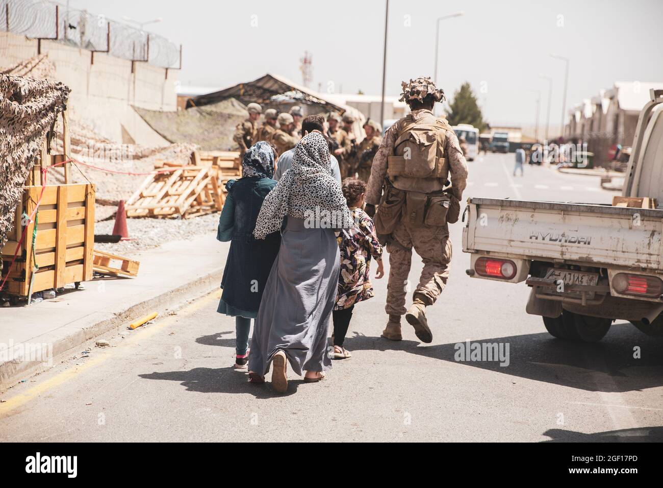 Kabul, Afghanistan. August 2021. Eine US-Marine mit dem Special Purpose Marine Air-Ground Task Force/Crisis Response Team begleitet eine afghanische Familie während der Operation Allies Refuge am 21. August 2021 in Kabul, Afghanistan, zum Evakuierungsort am Hamid Karzai International Airport. Quelle: Planetpix/Alamy Live News Stockfoto