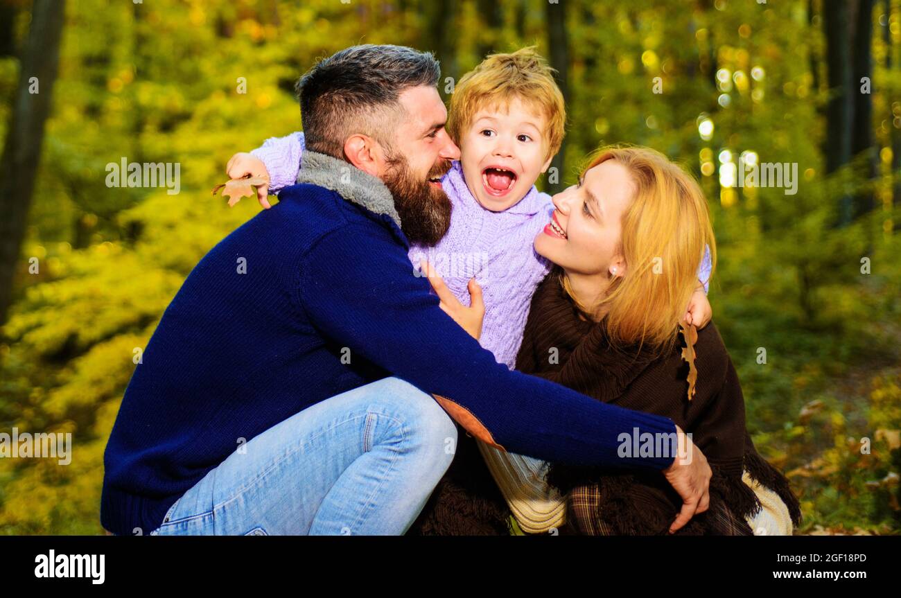 Glückliche Eltern mit kleinem Sohn im Herbstpark. Mutter, Vater und Kind zusammen in gelber Natur. Familie, Elternschaft. Stockfoto