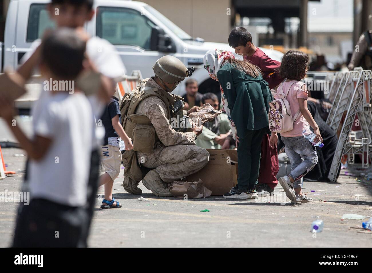 Kabul, Afghanistan. August 2021. Ein Marine mit Spezialeinsatzkommando der Marine-Luft-Boden-Task Force-Crisis Response-Central Command (SPMAGTF-CR-CC) versorgt ein Kind während einer Evakuierung am 21. August 2021 auf dem Hamid Karzai International Airport in Kabul, Afghanistan, mit verzehrfertigen Mahlzeiten. US-Dienstmitglieder unterstützen das Außenministerium bei einer geordneten Abseichung von designiertem Personal in Afghanistan. Foto von Sgt. Samuel Ruiz/USA Marine Corps/UPI Kredit: UPI/Alamy Live Nachrichten Stockfoto