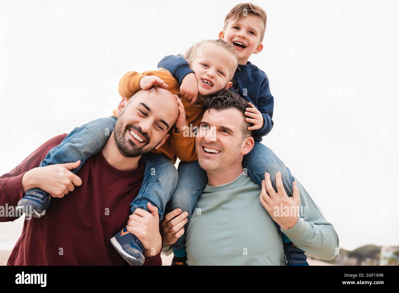 Schwule Väter und Söhne spielen gemeinsam in der Stadt – LGBT-Familienliebhaben-Konzept – Fokus auf das rechte Vatergesicht Stockfoto
