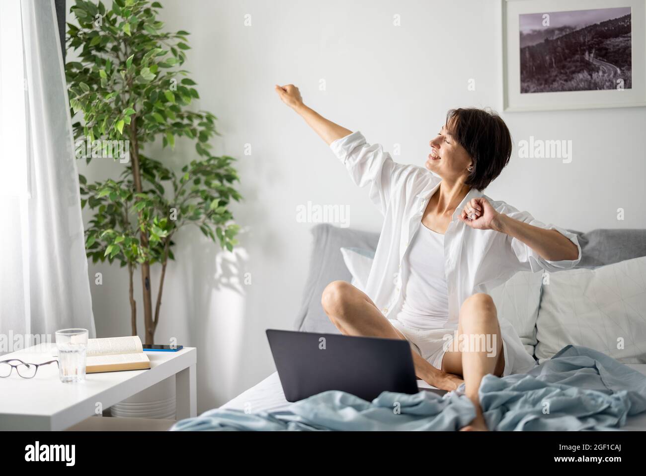 Frau mit Laptop im Bett Stockfoto