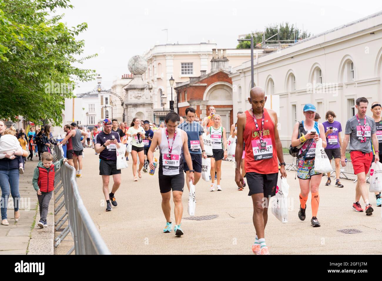 Läufer und Rennfahrer vom Big Half Marathon UK 2021 trugen die Goodie-Tasche zu Fuß zum Gaststättenzelt vor Queen's House London Greenwich Stockfoto
