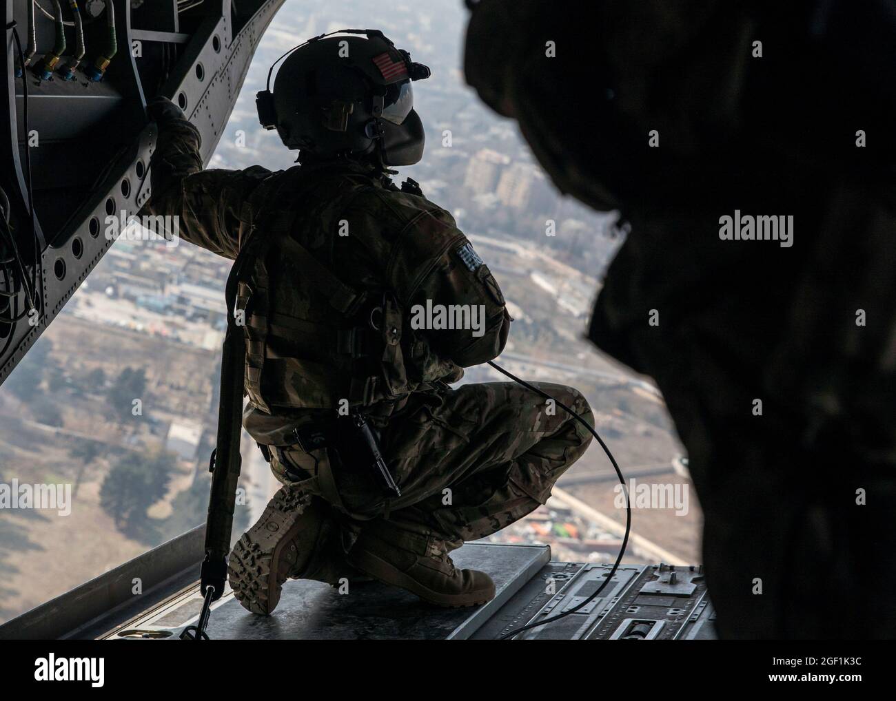 Ein US-Soldat, der der 10th Mountain Division zugewiesen wurde, untersucht die Landschaft von der Rückseite eines CH-47 Chinooks während eines Fluges über Kabul, Afghanistan, am 27. November 2019. (USA Army Reserve Foto von SPC. Jeffery J. Harris/ veröffentlicht) Stockfoto