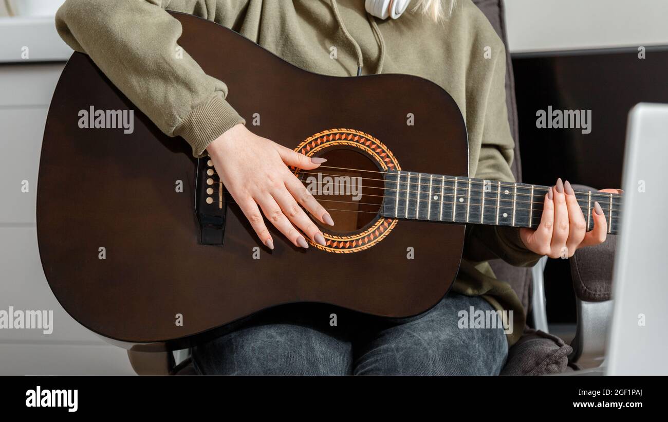 Online-Kurse Kurs Gitarre Ausbildung Musik e Bildung während Lockdown. Langes Webbanner. Online musikalische Gitarre Performance. Junge Frau spielt Stockfoto