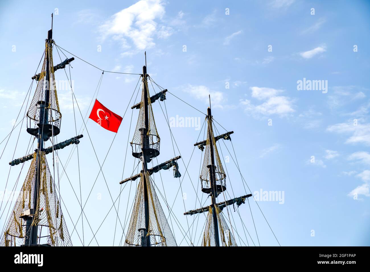 Die Masten des Schiffes mit der türkischen Flagge auf dem Hintergrund des blauen Himmels. Das Konzept von Reisen und Freiheit Stockfoto