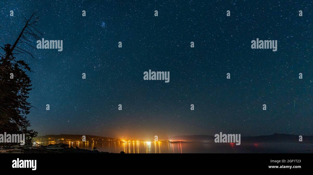 Nachtansicht der kleinen Stadt am Mount Waddington viele Sterne am dunklen Himmel. Stockfoto