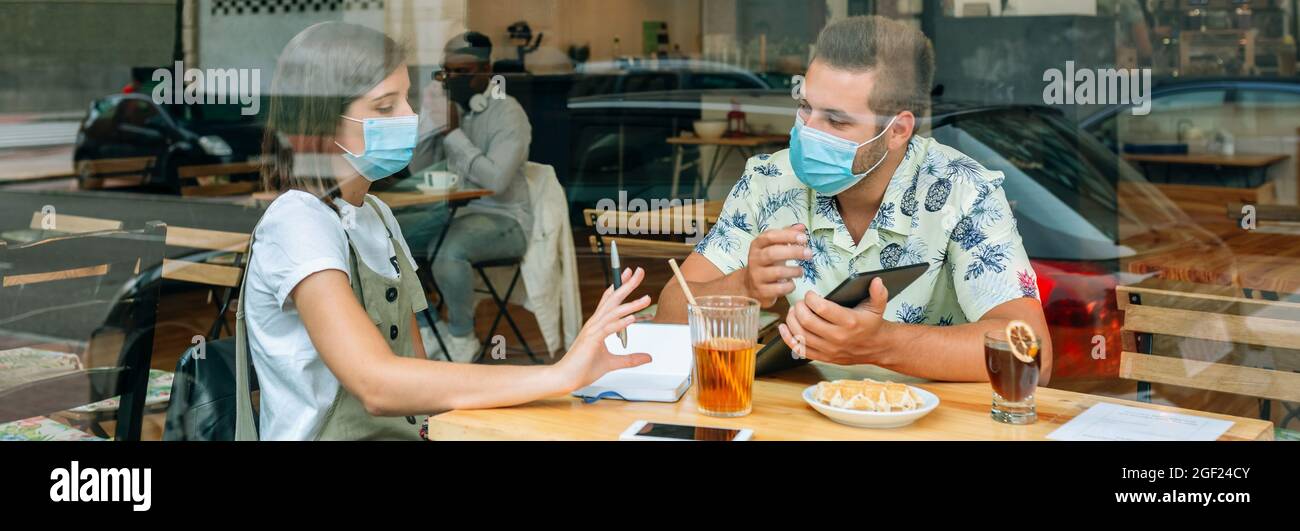 Mitarbeiter mit Maske, die ein zwangloses Geschäftstreffen abhalten Stockfoto