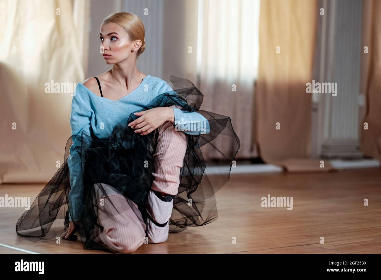 Balletttänzerin führt Dehnübungen durch, bevor sie eine Tanzprobe beginnt. Stockfoto