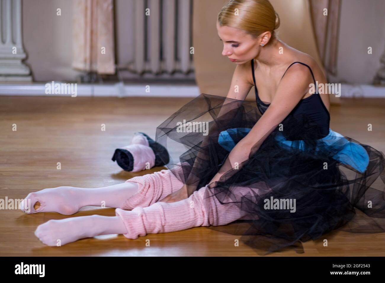 Balletttänzerin führt Dehnübungen durch, bevor sie eine Tanzprobe beginnt. Stockfoto