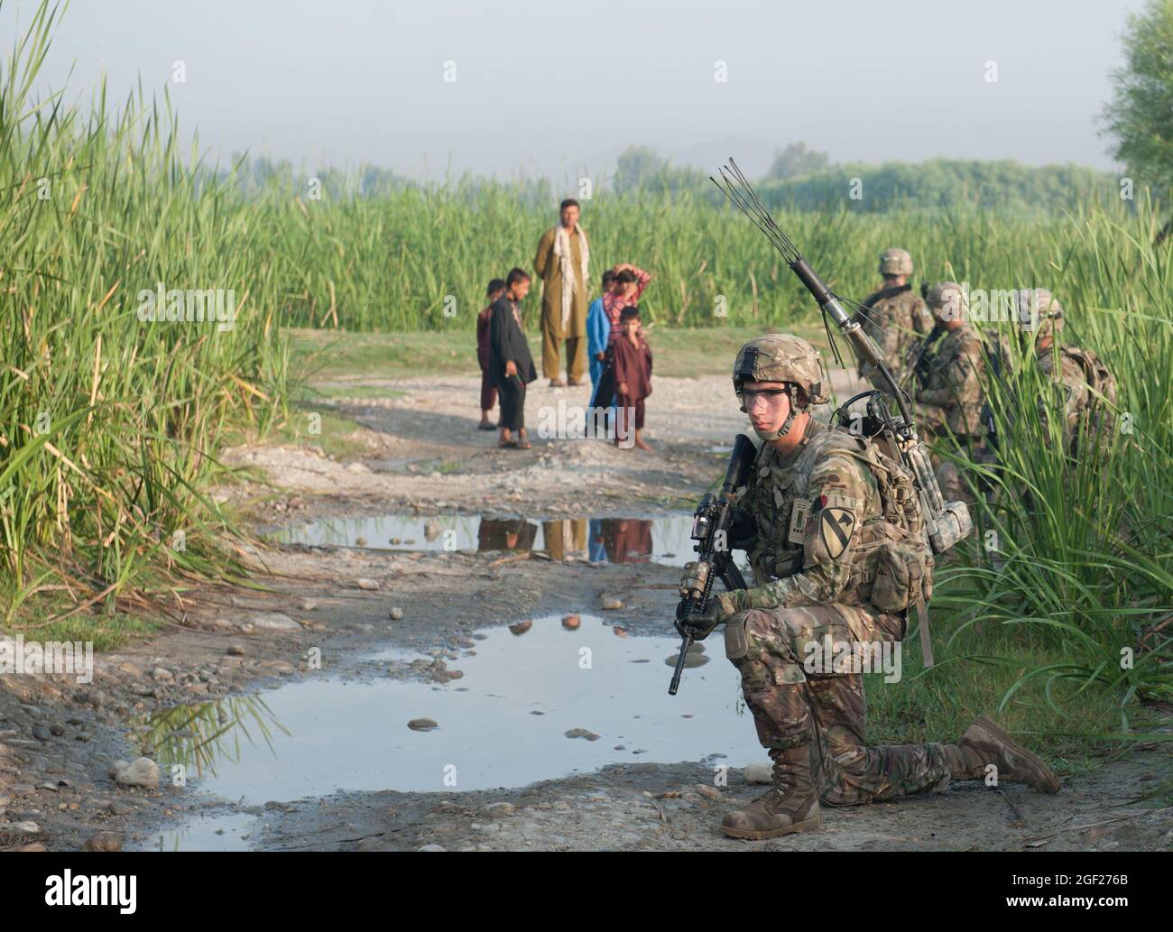 U.S. Army PFC. Nichola Peterson, der Bravo-Truppe, 4. Staffel, 9. Kavallerieregiment, 2. Panzerbrigade-Kampfteam, 1. Kavalleriedivision, zugewiesen wurde, zieht mit seinem Team während einer Anwesenheitspatrouille um die Vorwärtsoperationsbasis Fenty in der Provinz Nangarhar, Afghanistan, 22. August 2013, Sicherheit. Der Zweck der morgendlichen Patrouille war es, die Sicherheit von Fentys Umkreis zu überprüfen und die lokale Bevölkerung zu engagieren. (USA Foto der Armee-Nationalgarde von Sgt. Margaret Taylor/Freigegeben) Stockfoto