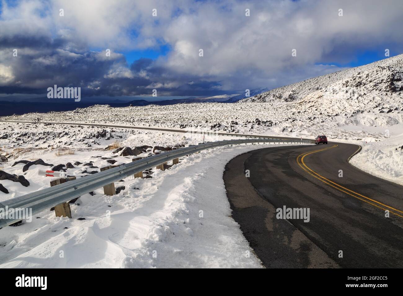 Eine Straße auf der Seite eines verschneiten Berges im Winter. Fotografiert auf der Bruce Road, Mount Ruapehu, Neuseeland Stockfoto