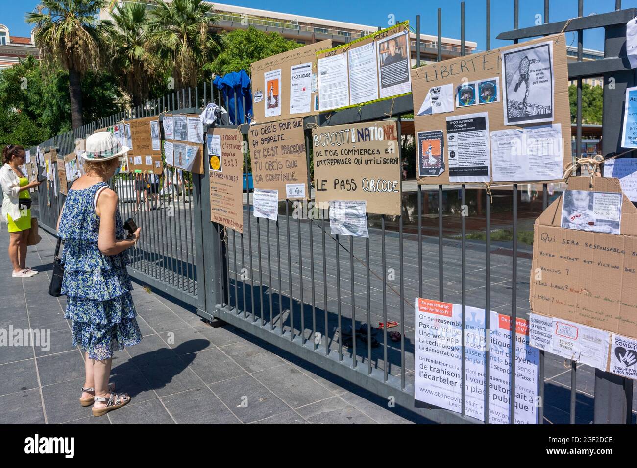 Nizza, Frankreich, Frau, die Anti-vax-Plakate auf der Straße liest, nach Demo, Anti-COVID-19-Impfung französische Demonstrationsschilder, Anti-Pass, covid-Impfgefahr, falsche Informationen, Herausforderungen der öffentlichen Gesundheit Stockfoto