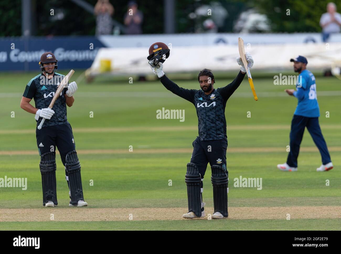 Ryan Patel von Surrey hebt seine Fledermaus, um sein Jahrhundert gegen Derbyshire in einem Royal London Cup-Spiel zu markieren. Surreys Tim David applaudiert (links). Stockfoto