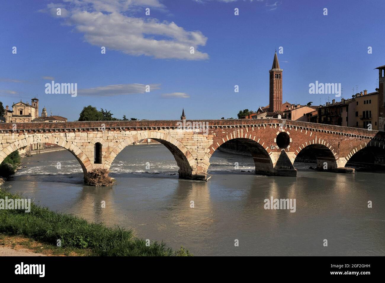 Hunderte von weißen Steinblöcken, die von den Römern geschnitten wurden, um ihre Brücke über die Etsch wieder aufzubauen, wurden aus dem Flussbett von Verona, Venetien, Italien, gerettet, nachdem deutsche Truppen vier der fünf alten Bögen im April 1945 sprengten. Die Blöcke wurden wiederverwendet, als der Eselsrücken Ponte Pietra in den Jahren 1957-9 wieder aufgebaut wurde, und ein Großteil der mittelalterlichen und 16. Jahrhundert Mauerwerk wurde auch ausgebaggert, um seine drei westlichen Bögen neu zu erstellen. Der römische Steinbogen auf der linken Seite hat in dieser Ansicht 2,000 Jahre Überschwemmungen, Brückeneinbrüche und Explosionen aus dem Krieg überlebt. Stockfoto