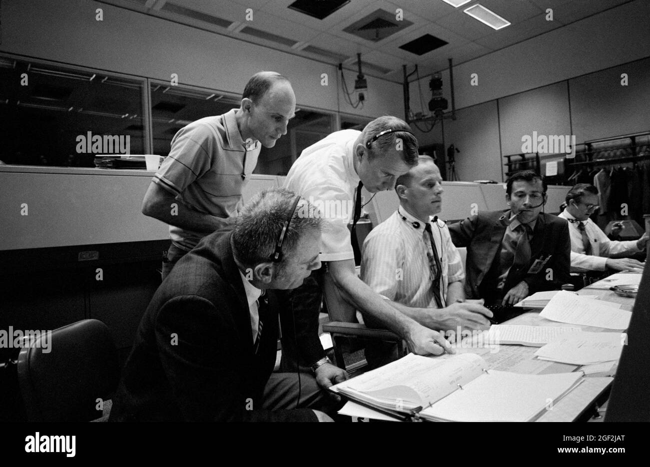 (14. April 1970) --- mehrere Personen, die für die Apollo 13-Mission wichtig sind, an Konsolen im Mission Operations Control Room (MOCR) des Mission Control Centers (MCC). Auf Konsolen sitzen von links nach rechts die Astronauten Donald K. Slayton, Direktor der Flugbesatzung, der Astronaut Jack R. Lousma, Raumschiff-Kommunikator Shift 3, und der Astronaut John W. Young, Kommandant der Apollo 13 Backup-Crew. Von links nach rechts stehen Astronaut Tom K. Mattingly II, der als Pilot des Apollo 13-Kommandomoduls ersetzt wurde, nachdem er gelernt hatte, dass er mit Masern herunterkommen könnte, und Astronaut Vance D. Brand, Sh Stockfoto
