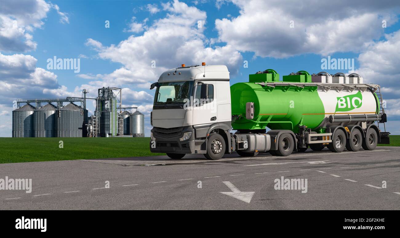 LKW mit einem Tank mit der Aufschrift Bio auf dem Hintergrund von Silos. Konzept für Biokraftstoffe. Stockfoto