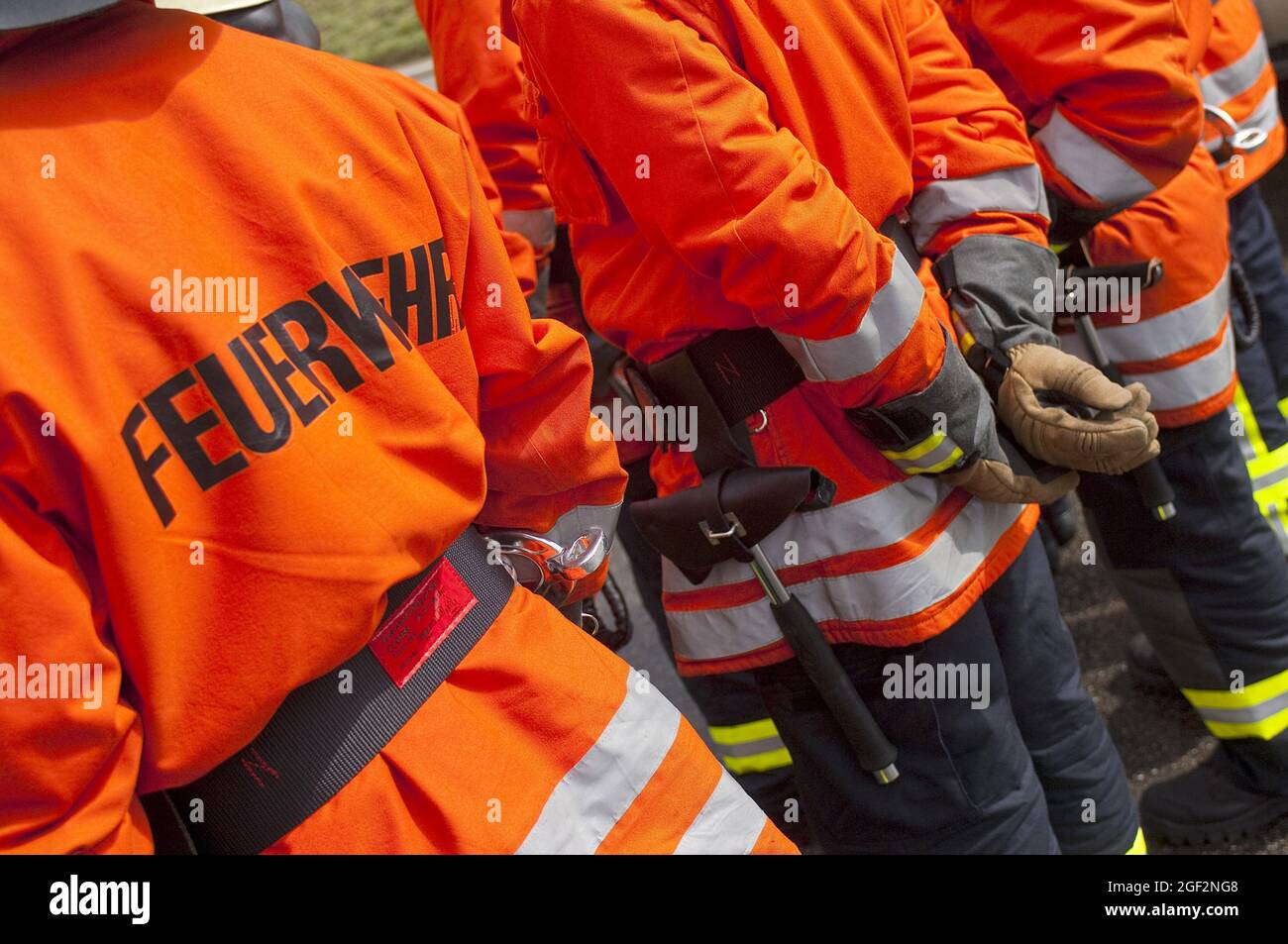 Feuerwehrleute stehen zusammen, retroreflektive Streifen und fluoreszierende Farben auf der Schutzkleidung, Deutschland Stockfoto