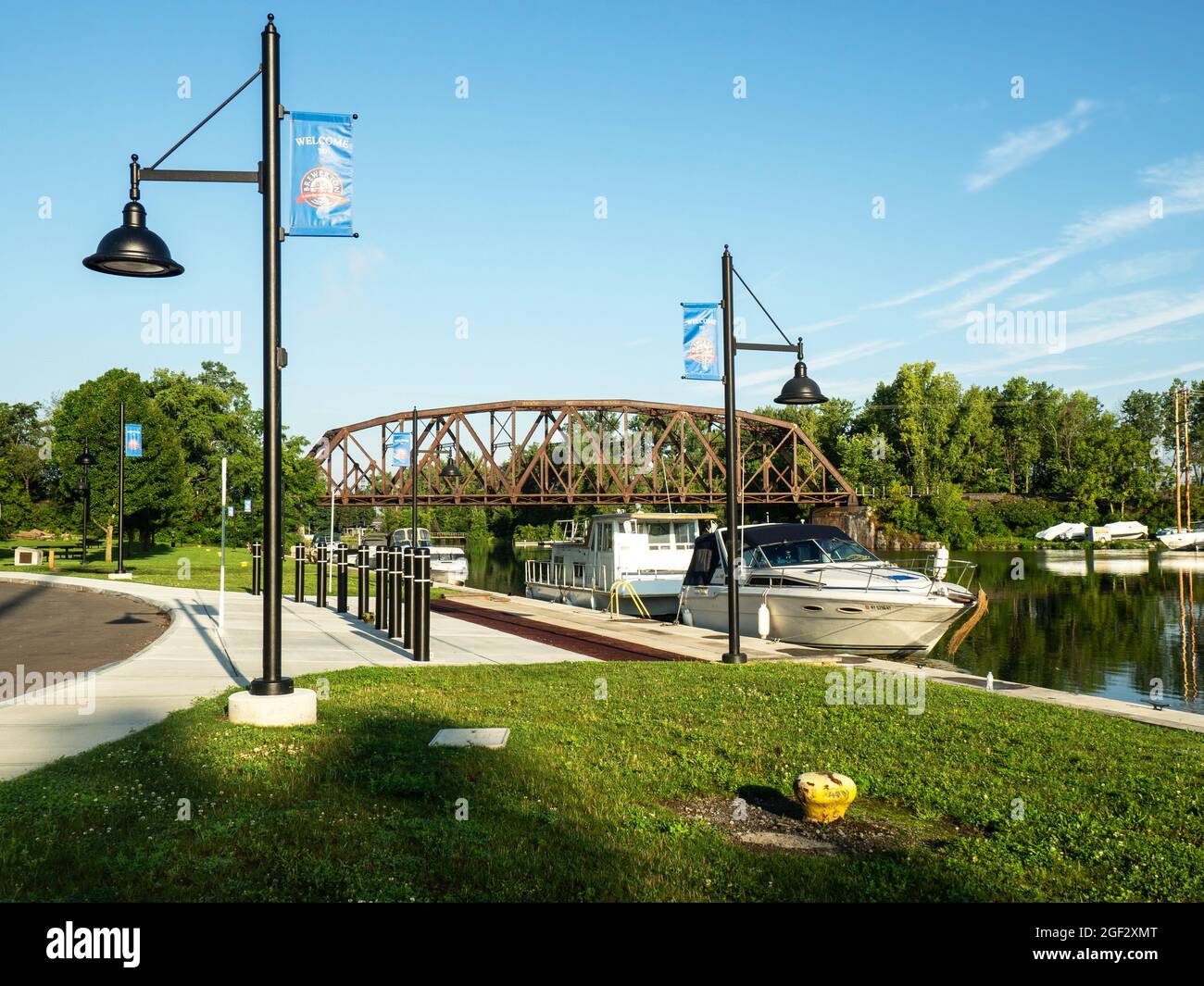 Brewerton, New York, USA. August 22,2021 .Park mit Eisenbahnbrücke über den Oneida Fluss in Brewerton, New York an einem ruhigen Sommermorgen Stockfoto
