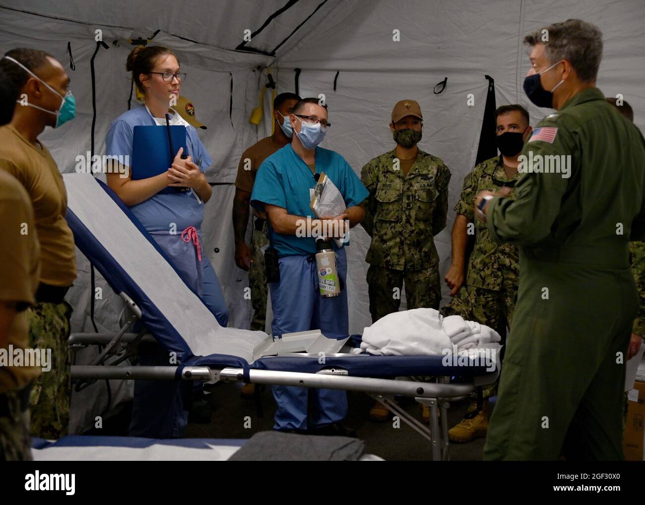 Capt. Kepper Pickard, Kommandant der Naval Air Station Sigonella, Cmdr. Ronald Cappellini, Executive Officer NAS Sigonella und NAS Sigonella Command Master Chief Anna Wood, berichten Matrosen vom Naval Medical Readiness Training Center Sigonella über die Mission des Verteidigungsministeriums, um die sichere Ausreise und Umsiedlung von US-Bürgern, Empfängern von Sondervisa für Immigration, zu erleichtern. Und gefährdete afghanische Bevölkerungen aus Afghanistan, 20. August 2021. Stockfoto