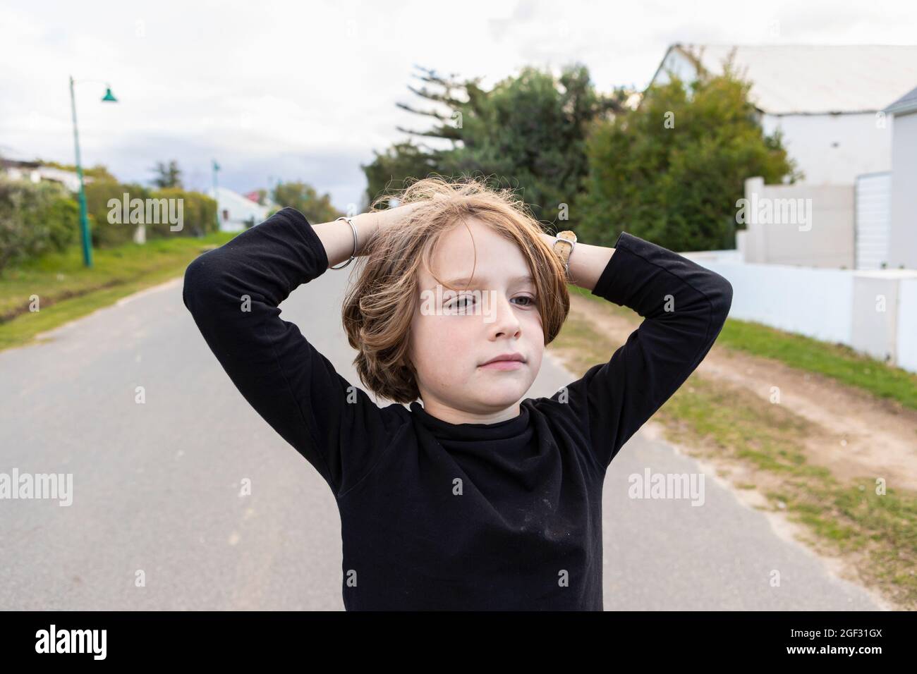 Achtjähriger Junge, Hände auf dem Kopf, Porträt Stockfoto