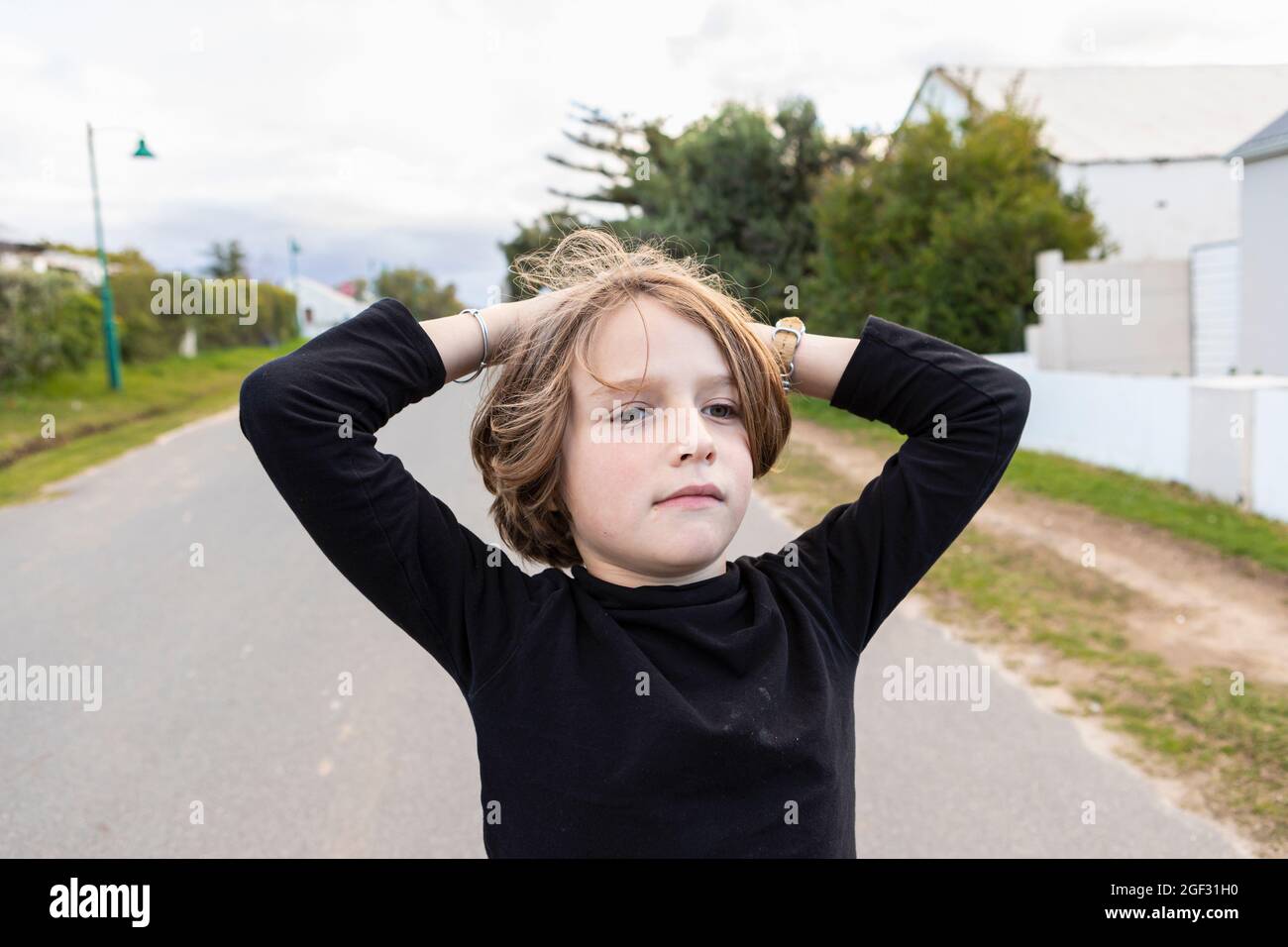 Achtjähriger Junge, Hände auf dem Kopf, Porträt Stockfoto